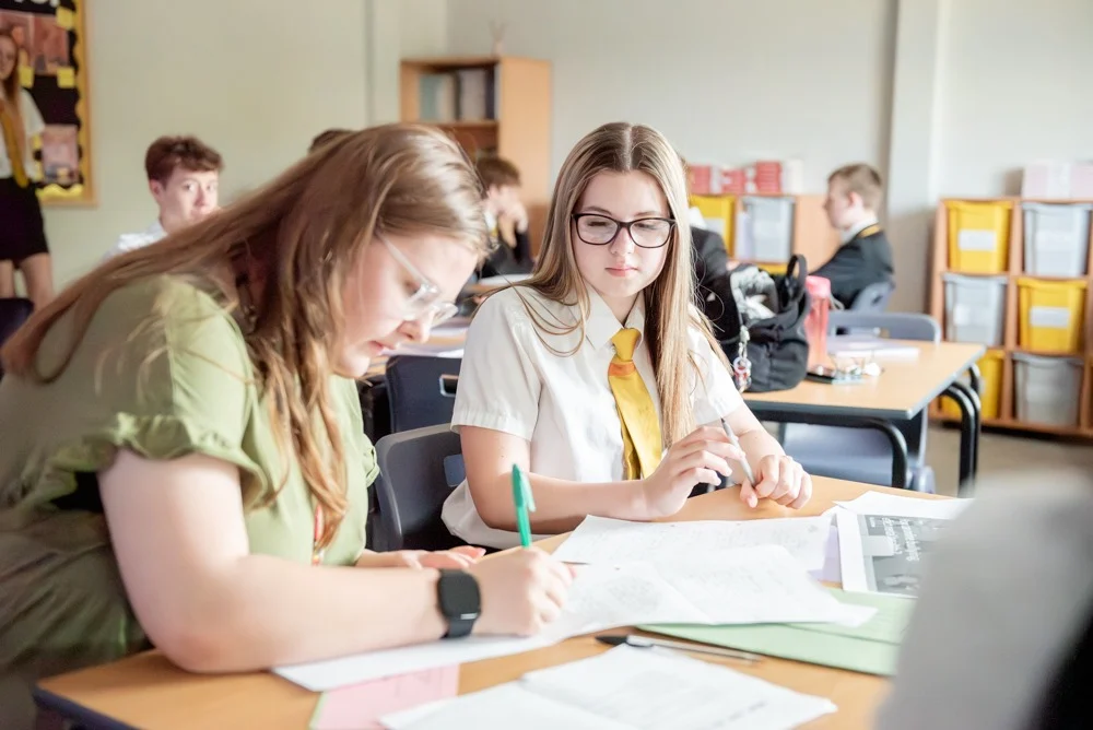 A member of staff working alongside a pupil in a lesson